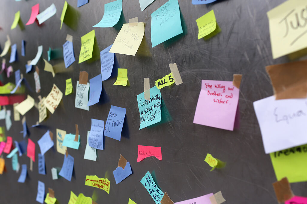 Protesters taped demands for police onto the base of the Gateway Arch after marching through St. Louis on Monday